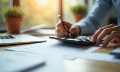 Main utilisant une calculatrice et écrivant sur une fiche de paie